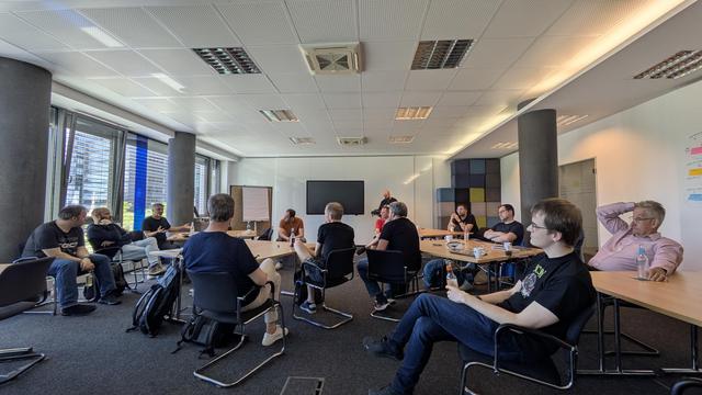 Meeting room with around 30 people discussing Java community and other topics