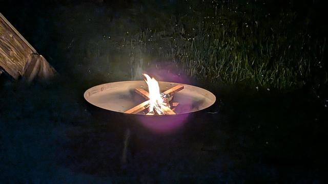 A small camp fire burning in the dark.